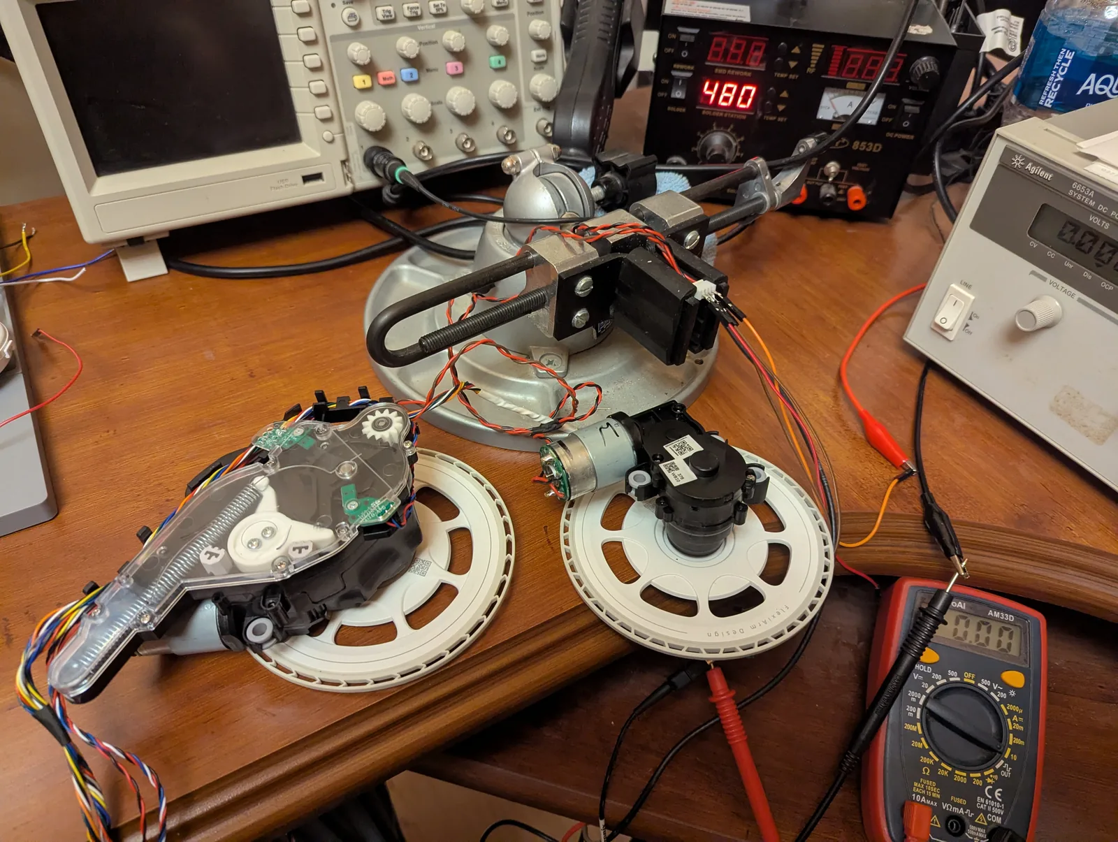 Left and right FlexiArm mop assemblies on the bench, one intact and one opened to show the gearmotor
